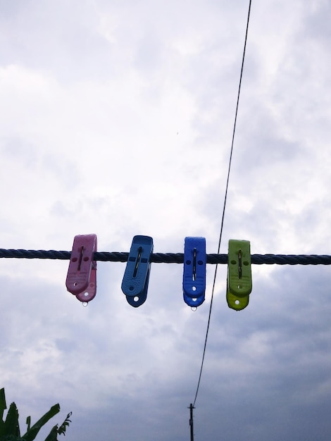 Low angle view of clothespin hanging against sky