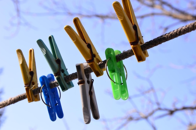 Photo low angle view of clothespins on clothesline against sky