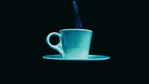 Photo low angle view of coffee being poured in cup against black background