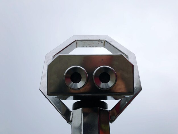 Photo low angle view of coin-operated binoculars against sky