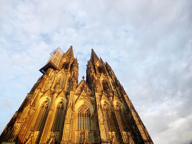 Low angle view of cologne cathedral against cloudy sky