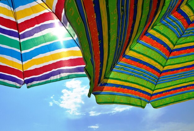 Low angle view of colorful beach umbrella against sky