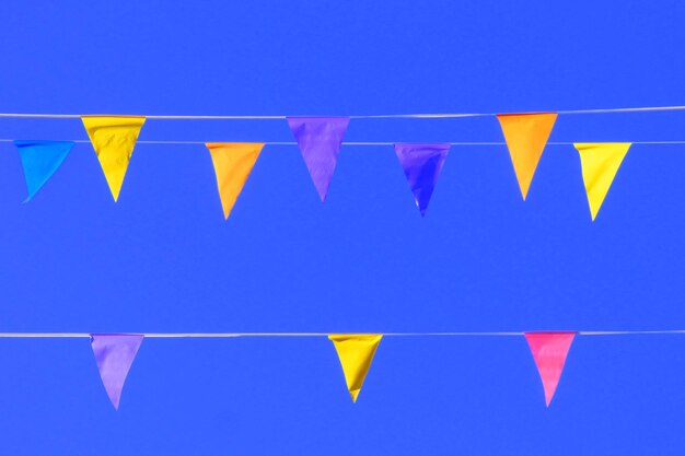 Foto vista a basso angolo di buntings colorati appesi contro il cielo blu