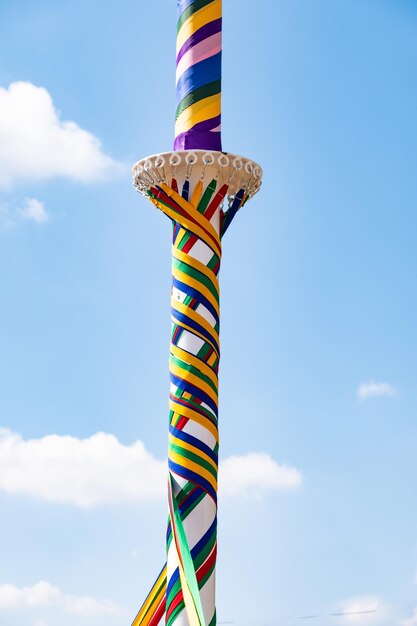 Photo low angle view of colorful fabrics wrapped on pole against blue sky