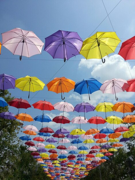 Foto vista a basso angolo di ombrelli colorati appesi contro il cielo