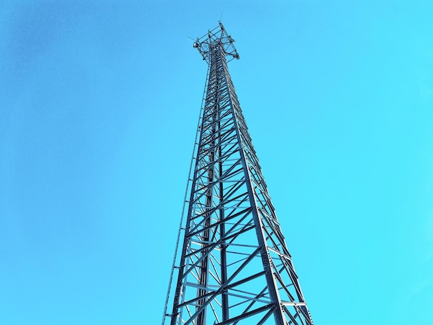 Low angle view of communications tower against blue sky