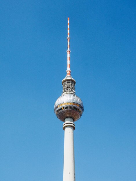 Low angle view of communications tower against blue sky