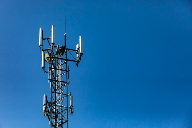 Low angle view of communications tower against blue sky