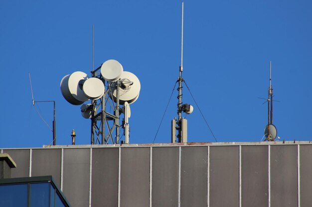 Low angle view of communications tower against clear blue sky