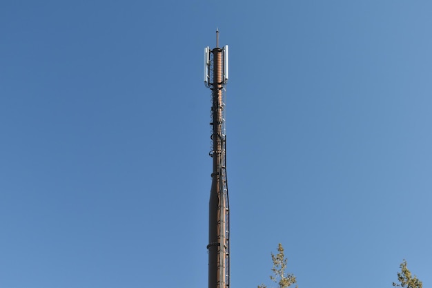 Low angle view of communications tower against clear blue sky