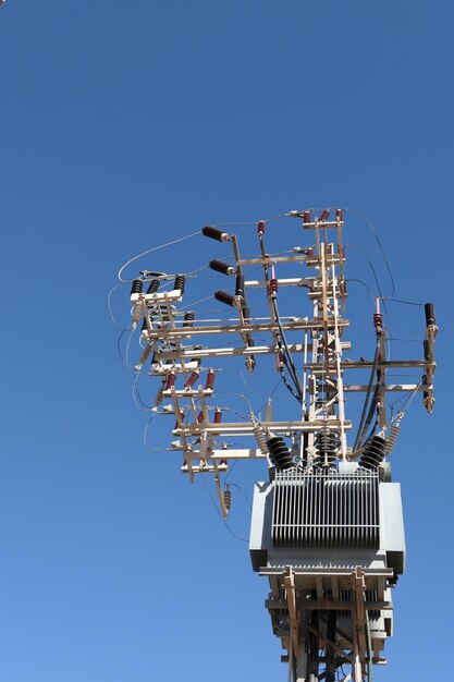 Low angle view of communications tower against clear blue sky