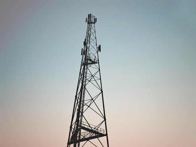 Photo low angle view of communications tower against sky