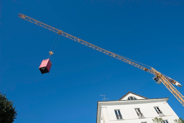 Photo low angle view of container on crane against clear blue sky