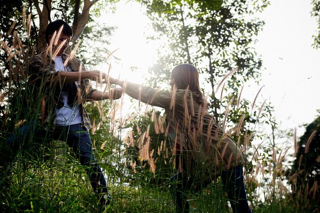 Photo low angle view of couple holding hands against trees