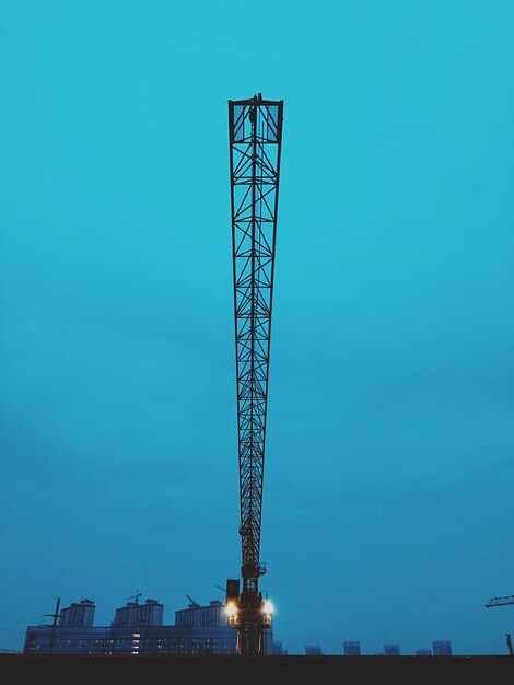 Low angle view of crane against blue sky