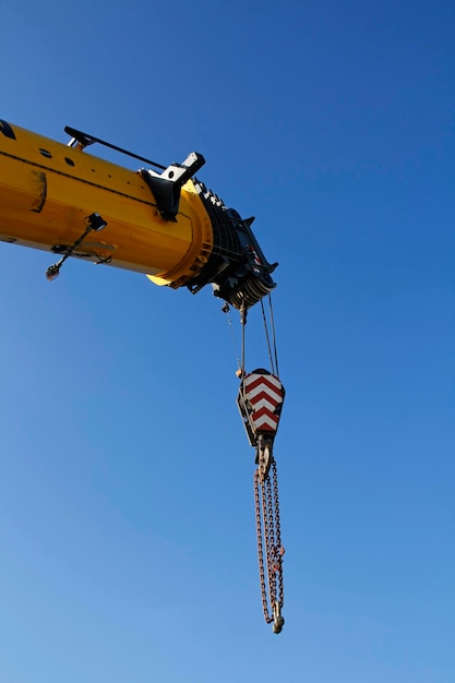 Low angle view of crane against clear blue sky