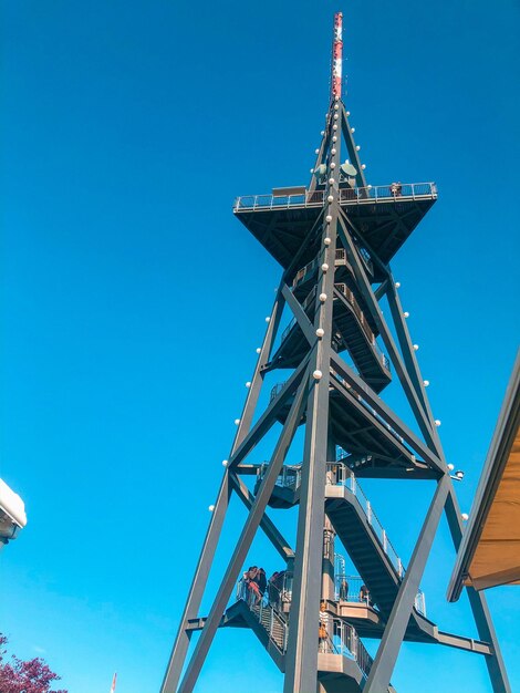 Low angle view of crane against clear blue sky