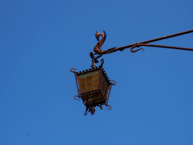 Low angle view of crane against clear blue sky