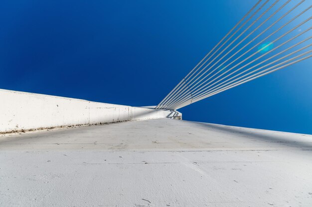 Low angle view of crane against clear blue sky