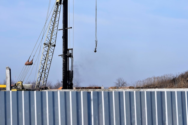 Low angle view of crane against clear blue sky