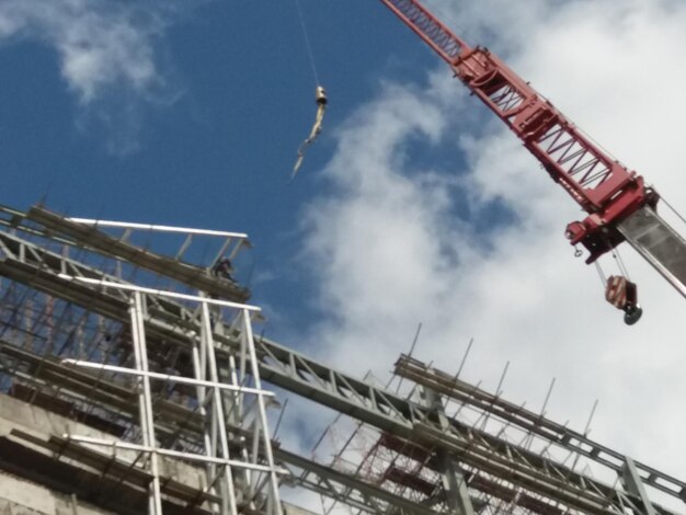 Low angle view of crane against sky