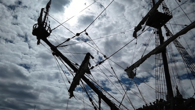 Photo low angle view of cranes against cloudy sky