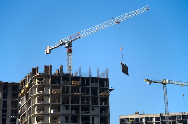 Foto vista a bassa angolazione delle gru sul cantiere contro il cielo