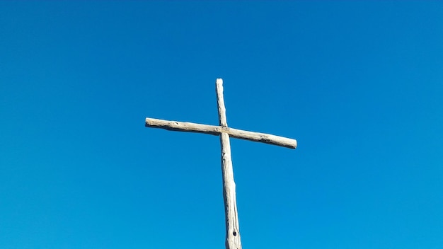 Low angle view of cross against clear blue sky