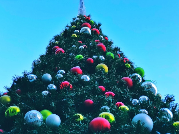 Low angle view of decorations on christmas tree against clear sky