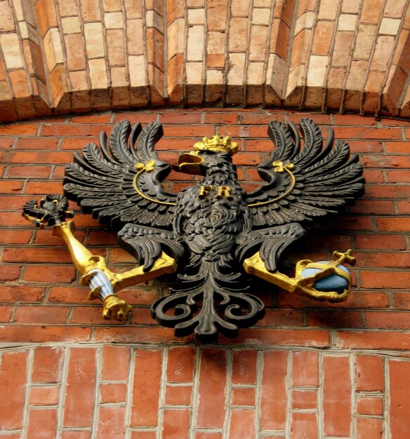 Photo low angle view of eagle sculpture on brick wall