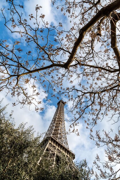 Photo low angle view of eiffel tower against cloudy sky