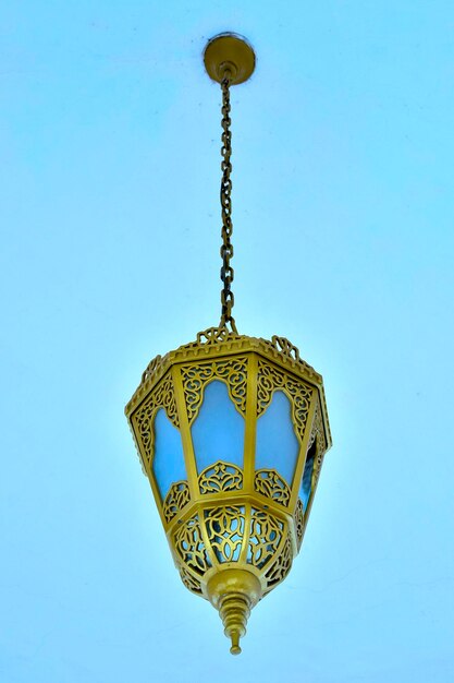 Low angle view of electric lamp against blue sky