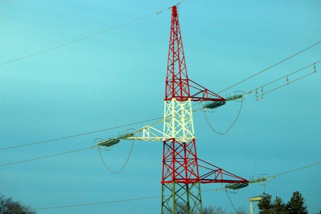 Low angle view of electricity pylon against blue sky