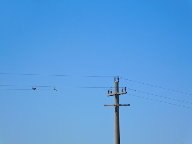 Photo low angle view of electricity pylon against clear blue sky