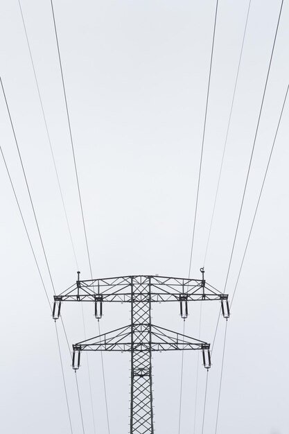 Low angle view of electricity pylon against clear sky