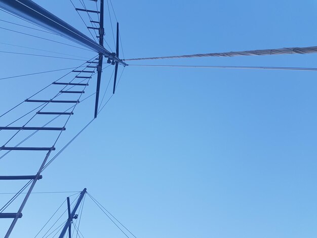 Low angle view of electricity pylon against clear sky