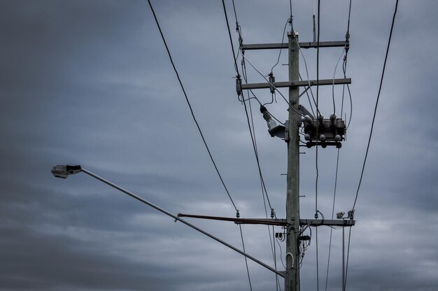 空に照らされた電力柱の低角度の眺め