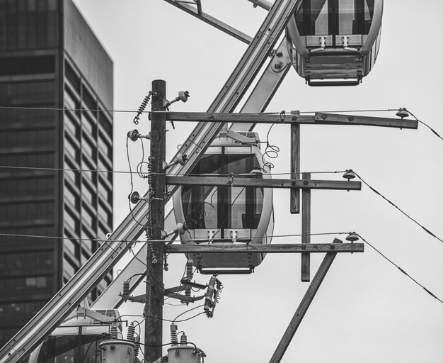 Photo low angle view of electricity pylon by ferris wheel against sky