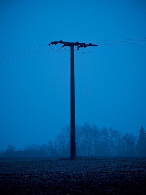 Photo low angle view of electricity pylon on field against clear sky