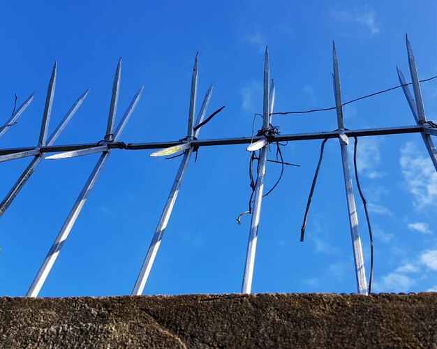 Low angle view of electricity pylon on field against sky