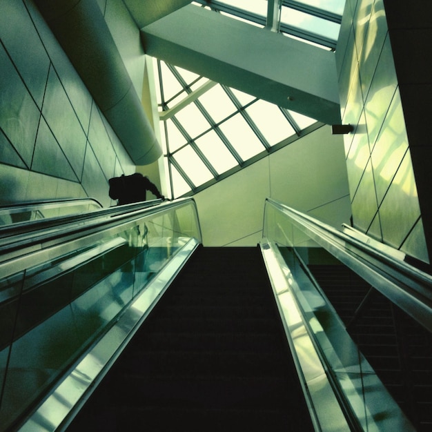 Premium Photo Low angle view of escalator against glass ceiling