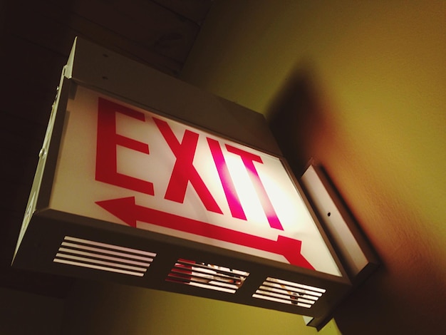 low angle view of exit sign mounted on wall