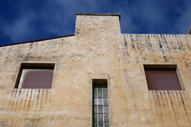 Low angle view of face on old building against sky