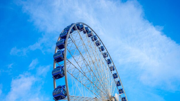 Low angle view of ferris wheel against blue sky