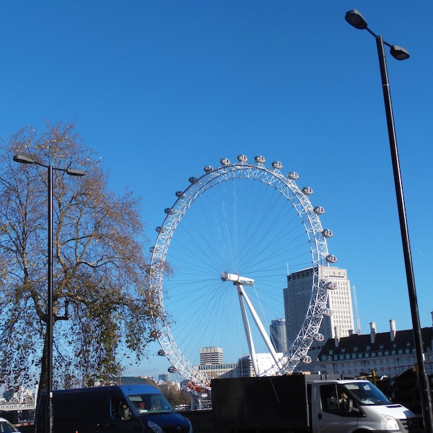 Low angle view of ferris wheel against blue sky