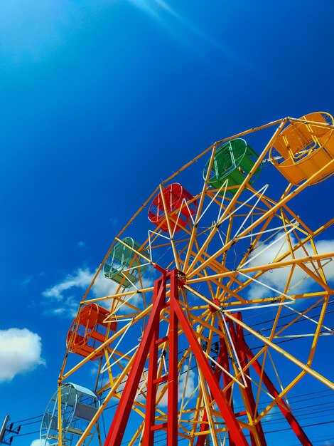 Low angle view of ferris wheel against blue sky