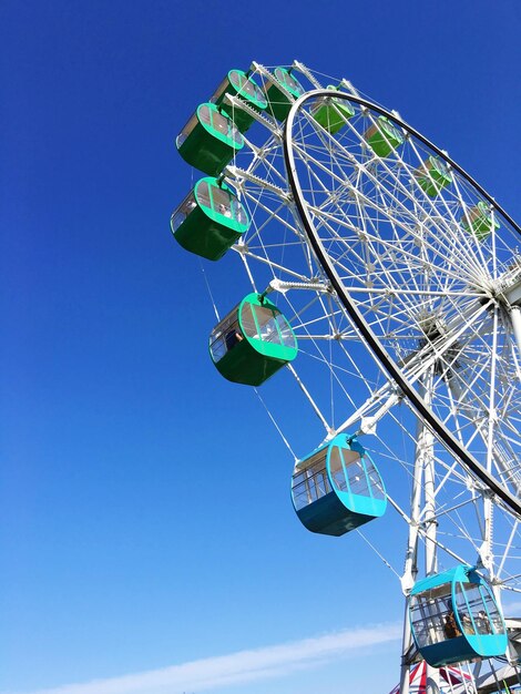 Low angle view of ferris wheel against blue sky