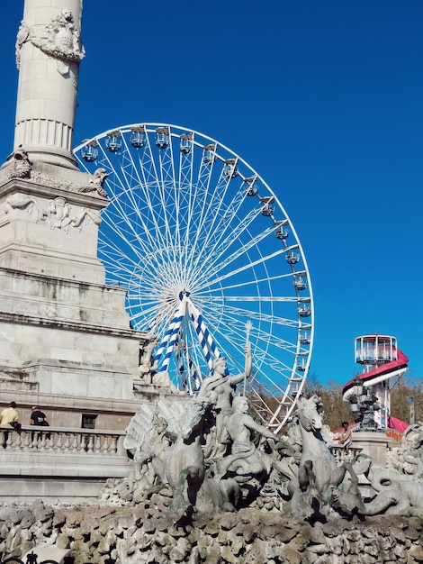 Low angle view of ferris wheel against blue sky