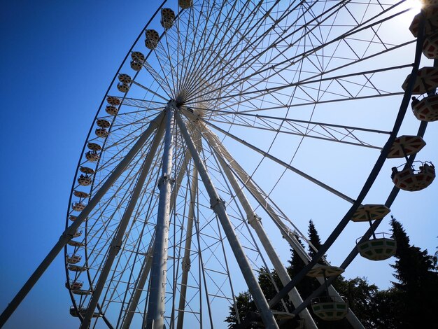 Low angle view of ferris wheel against blue sky