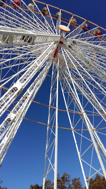 Foto vista a bassa angolazione della ruota panoramica contro un cielo blu limpido